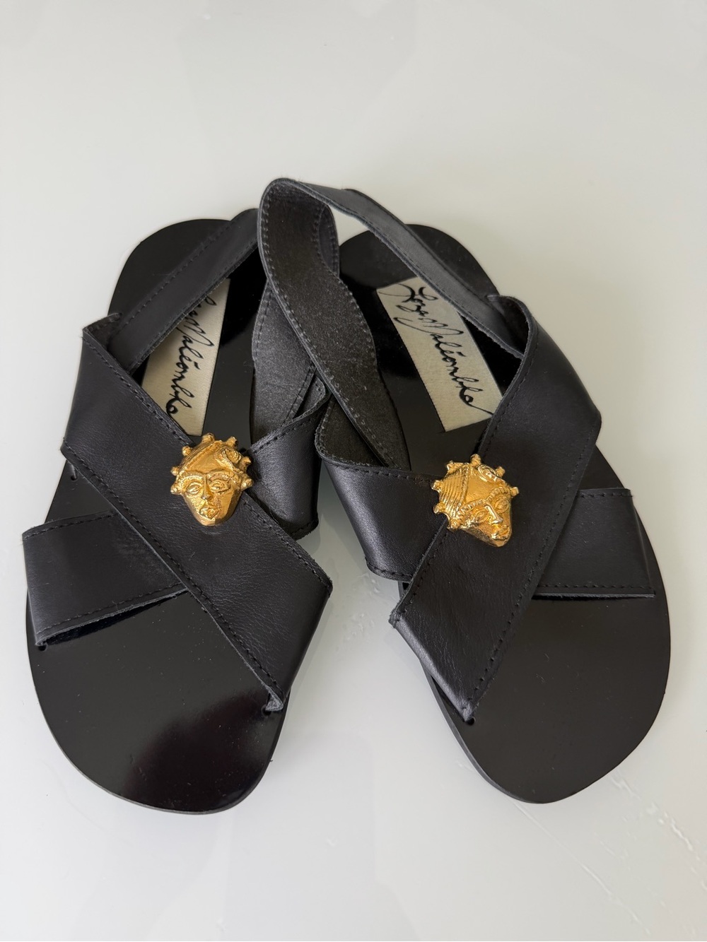 Black Leather Cross-Strap Sandals with Gold Medallion Accent